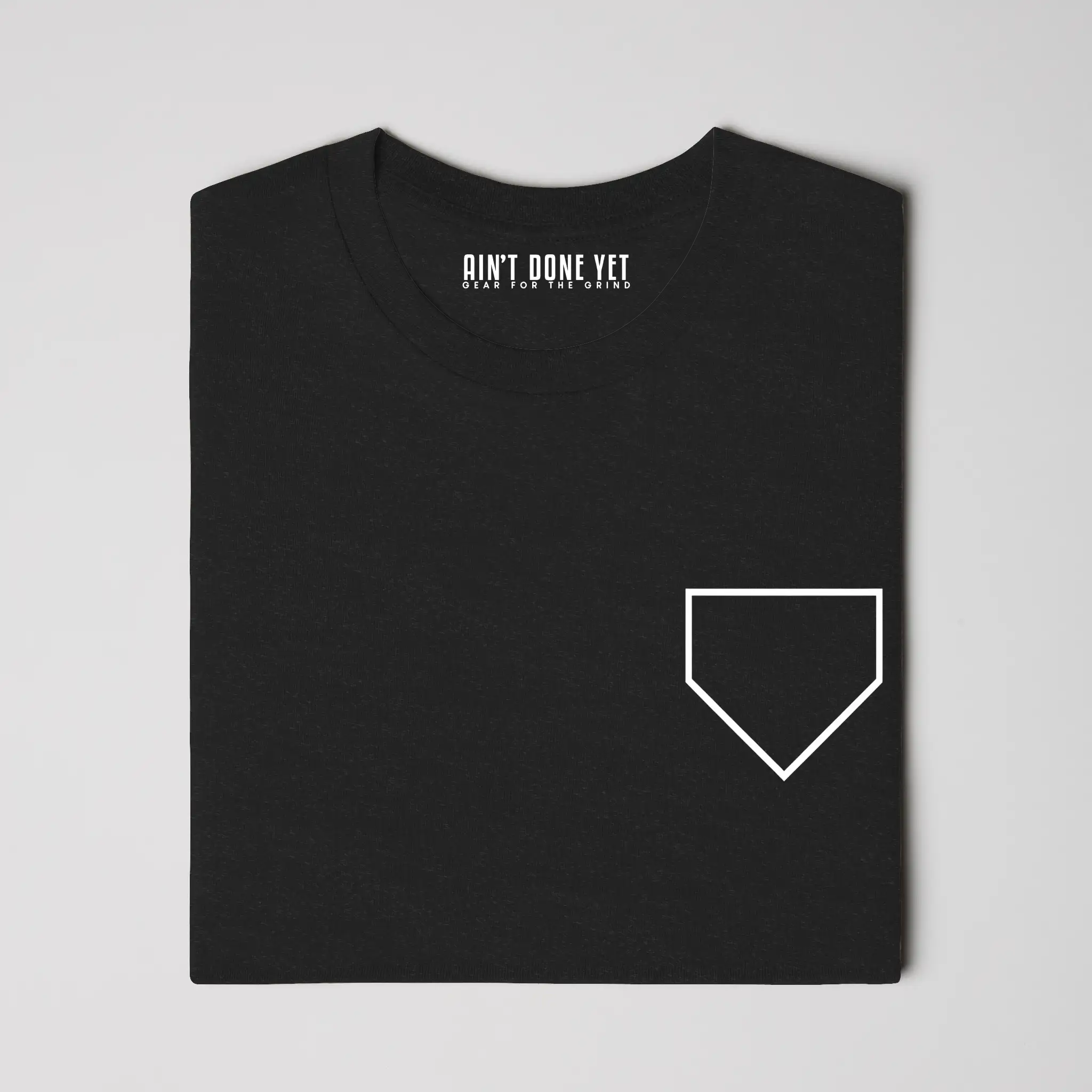 Middle Middle Tee with home plate graphic on front and baseball seam design with Ain’t Done Yet branding on back
