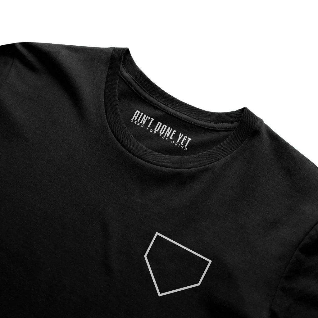 Middle Middle Tee with home plate graphic on front and baseball seam design with Ain’t Done Yet branding on back

