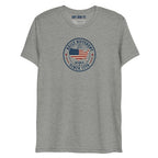 Built Different America 250 athletic grey tri-blend t-shirt featuring patriotic circular emblem with American flag and 1776 design.