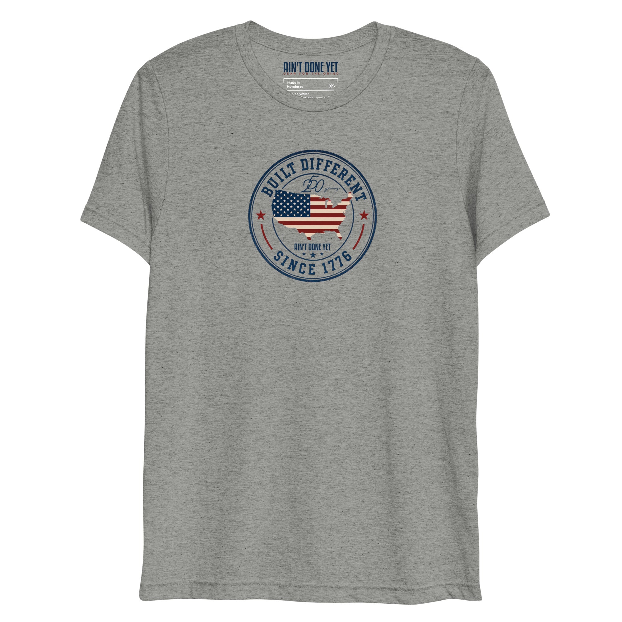 Built Different America 250 athletic grey tri-blend t-shirt featuring patriotic circular emblem with American flag and 1776 design.