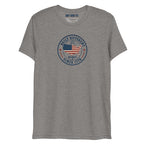 Built Different America 250 grey tri-blend t-shirt featuring patriotic circular emblem with American flag and 1776 design.