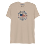 Built Different America 250 tan tri-blend t-shirt featuring patriotic circular emblem with American flag and 1776 design.