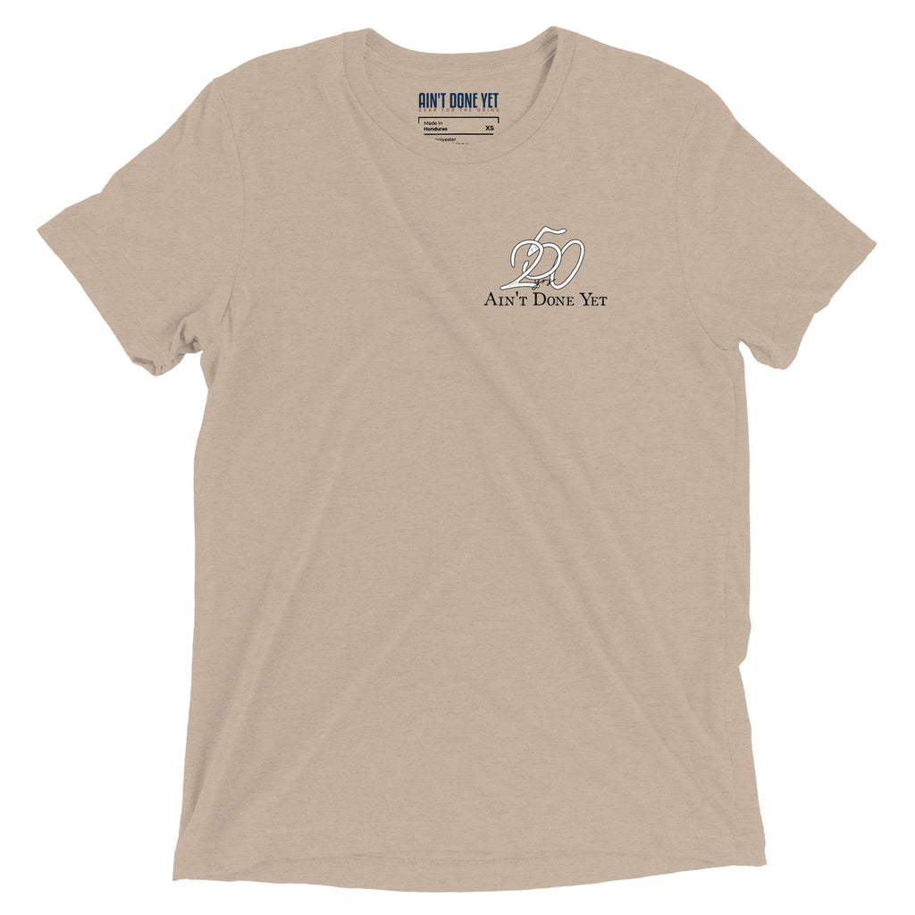 America 250 tan t-shirt featuring distressed 250 graphic integrated with the Ain't Done Yet logo in a clean patriotic design.