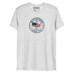 Built Different America 250 white fleck tri-blend t-shirt featuring patriotic circular emblem with American flag and 1776 design.